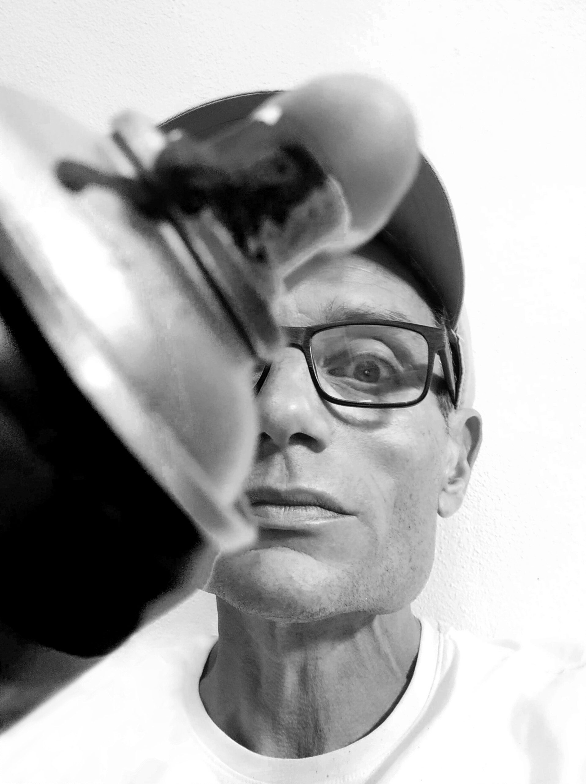  A close-up black-and-white photograph of Harry Bunce holding a spray paint can, highlighting his artistic tools and process.