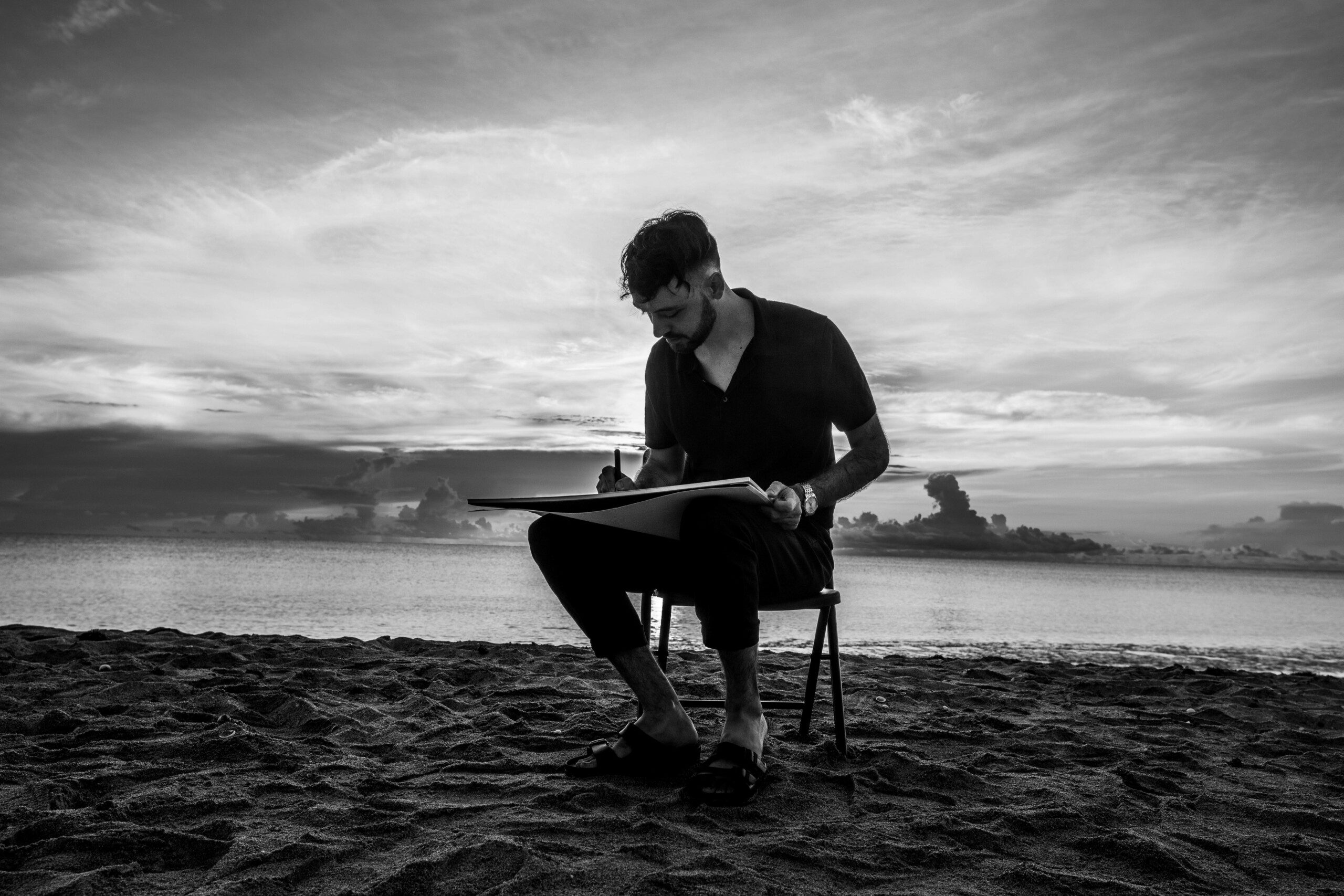 Artist KEF! painting outdoors on sandy beach