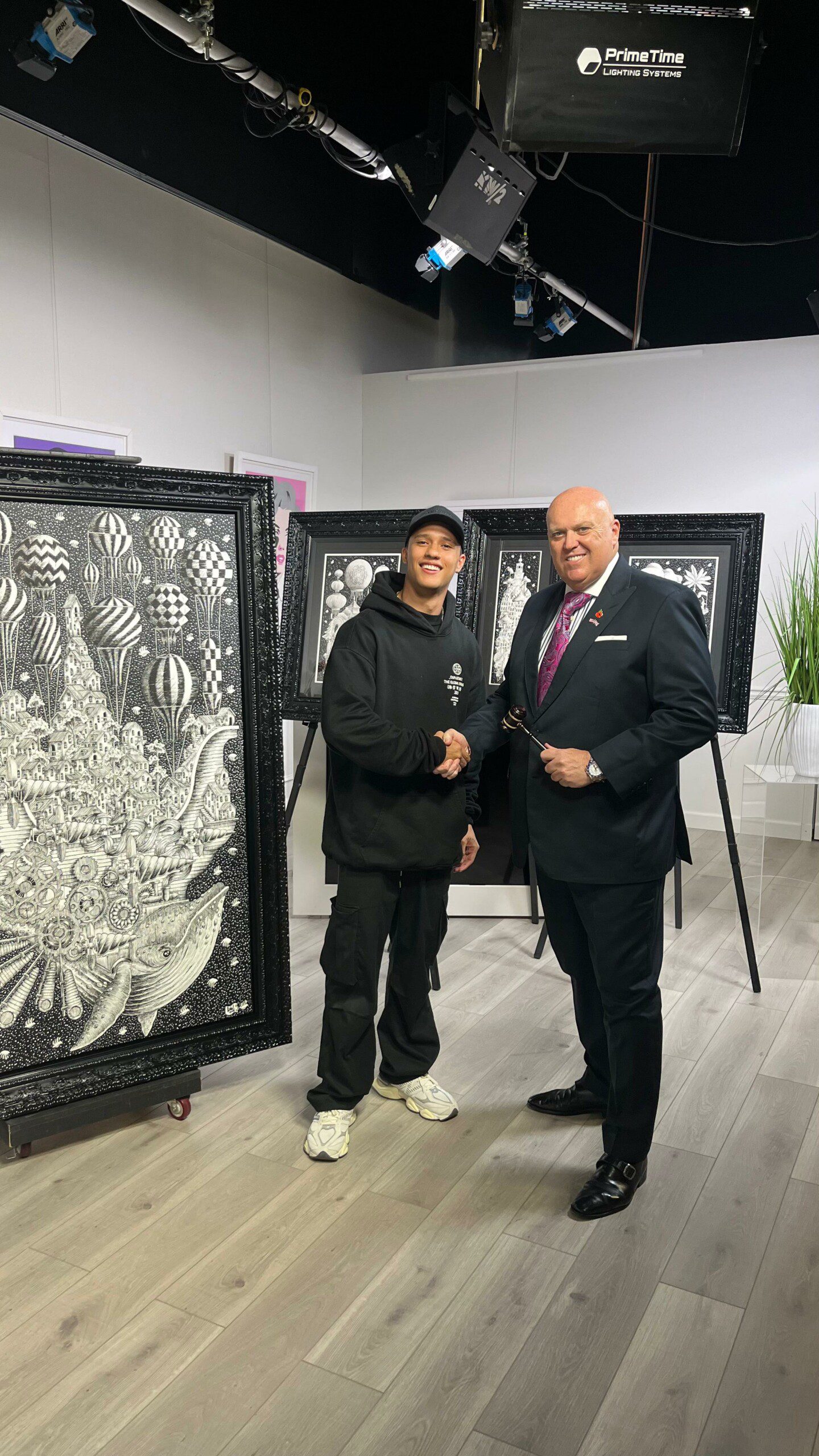 the Colombian artist Pedro Ortiz Muñoz live at The Fine Art Auction standing in front of his original artwork with auctioneer Richard English